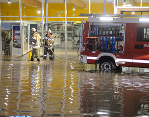 Samstag gegen 22 Uhr, Ortsteil Graf bei Grins: Feuerwehrmänner pumpen Wasser im Eingangsbereich eines Kfz-Händlers ab.
