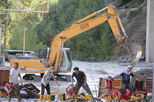 Bei den Aufräumarbeiten im Gewerbegebiet Grins/Graf ist vor allem Körper-Einsatz gefragt. Der Bagger räumt das Flussbett der Sanna.