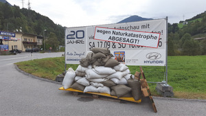 Sandsäcke und ein Info-Plakat vor dem Autohaus Zangerl.