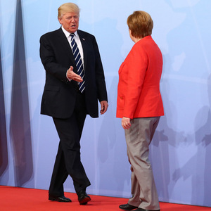 Selbstbewusst marschiert Donald Trump auf die deutsche Kanzlerin zu, packt sie am Ellbogen und schüttelt ihre Hand.