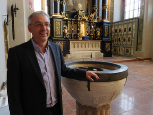 Pfarrer Jakob Patsch neben dem
versetzten Taufbecken, im Hintergrund der „frisch aufpolierte“ Hochaltar.