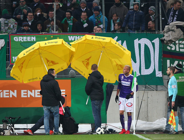 Mit Sonnenschirmen mussten die Austria-Kicker bei Eckbällen im Derby vor Gegenständen aus dem Rapid-Sektor geschützt werden.