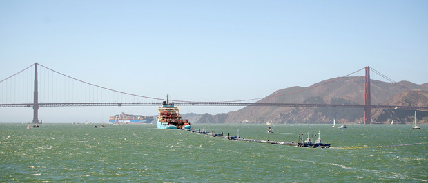 Eine riesige schwarze Kunststoffröhre mit der Aufschrift "System 001" zieht durch die Bucht von San Francisco. Im Schlepptau eines Schiffes hält sie Kurs auf den größten Müllteppich der Welt.