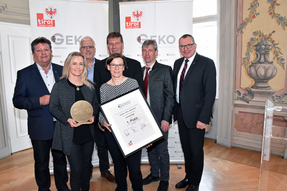 Gemeindeverbandspräsident Ernst Schöpf, BM Manfred Köll, BM Jakob Wolf, BM Hansjörg Falkner und LR Johannes Tratter (v. l.) feierten mit Sandra Friedl und Patrizia Pichler (v. l., Oetztalpflege) die Auszeichnung.