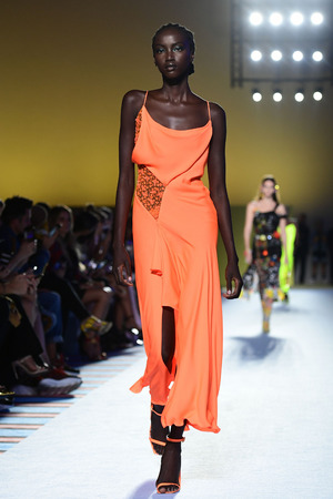 Bei Versace gesellt sich zum sanften Orangeton zarte Spitze und fließender Stoff. Selbst die Schuhe sind unifarben.