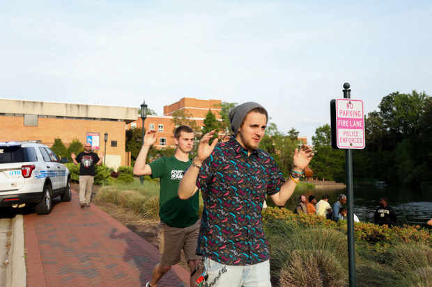 Mit erhobeben Händen versließen die Studenten das Uni-Gelände.