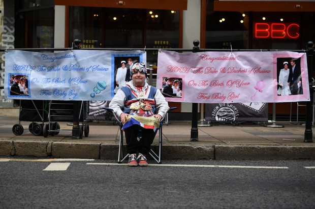 Dieser Royal-Fan campiert bereits seit Tagen in Windsor und hält Glückwunsch-Plakate in Blau und Rosa parat.