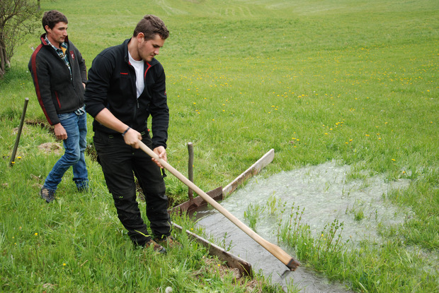 Mathias (l.) und Lukas Schöpf aktivieren die Rieselbewässerung in Ried.