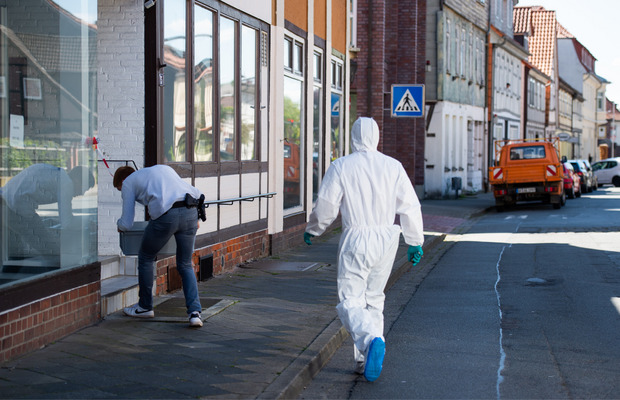 Ein Polizist und ein Mitarbeiter der Spurensicherung beim Tatort in Wittingen.
