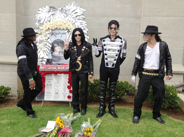 Michael-Jackson-Imitatoren posieren vor einem Andenken.