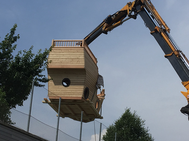 Per Kranwagen wurde das hölzerne Spielschiff auf das Dach des Kinderzentrums Absam-Eichat gehoben.