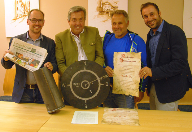 Der Gemeindevorstand mit Peter Wille, BM Rupert Schuchter, Toni Monz und Daniel Thöni (v. l.) legt Zeitungsberichte über die "Pfunds-Kerle" sowie Urkunden in eine Zeitkapsel, die am Pfunds-Kerle-Platz einbetoniert wird.