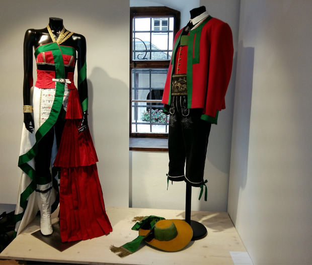 Pustertaler Tracht einmal anders: Anna Oberdorfer interpretiert Farben und Aussehen neu und gestaltet ein schulterfreies Abendkleid, das mit weißen Stiefeln getragen wird.