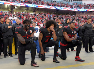 NFL-Profi Colin Kaepernick (Mitte) demonstrierte 2016 als Erster per Kniefall bei der Nationalhymne gegen Polizeigewalt gegen Schwarze und Rassismus. US-Präsident Trump tobte.